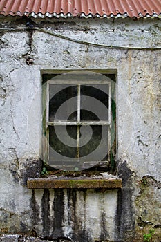 Window of dilapidated house in rotten frame