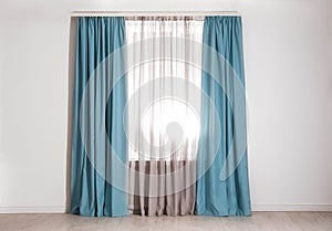 Window with elegant curtains in empty room