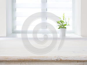Window with flower pot as blurred background for wooden table
