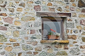 window with flowers on the background of a stone wall