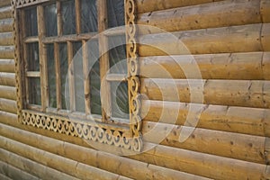 Window in folk style. House in Russia. Window frame carved from wood. Pattern along frame