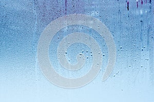 Window glass with condensation, high humidity in the room, large water droplets, cold tone photo