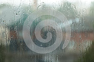 Window glass with droplets on rainy day, closeup