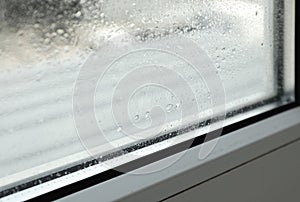 Window glass with drops of condensate indoors, closeup