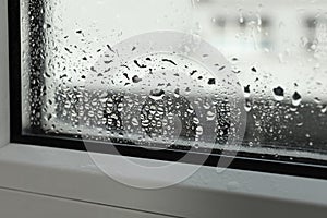 Window glass with drops of condensate indoors, closeup