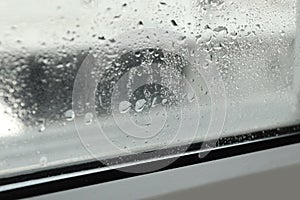 Window glass with drops of condensate indoors, closeup