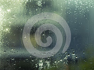 Window glass with water drops and glitters