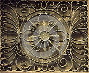 Window grate from old rusty iron on a stone wall. Photo from Spain