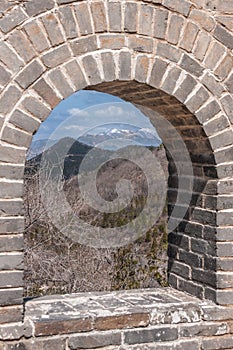 Window in Great Wall of China shows mountains, Beijing.