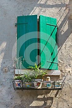 Window with green shutters and some plants in Malcesine on Lake Garda in Italy