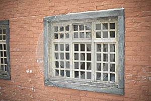 Window with grille in wall. Old window. Wall of house