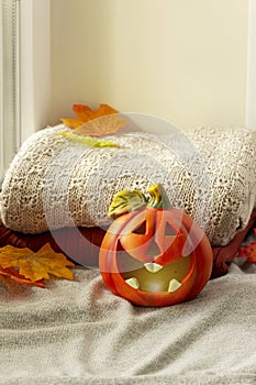 Window with Halloween decoration. Pumpkin with candle