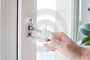 The window handle cracked. The man holds it in his hand, the iron pins are visible