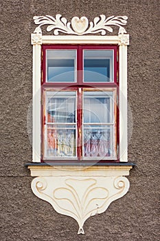 Window on a historic building decorated with sgraffito.