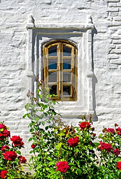 Window of house and red rose flowers in Kazan Kremlin, Russia