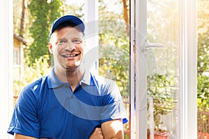 Window installer in blue uniform standing in the room