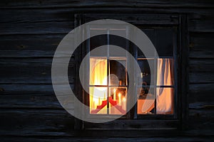 Window of log hut with a candle holder as christmas decoration