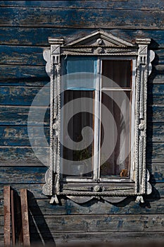 Window with lugged architrave as part of old blue wooden house
