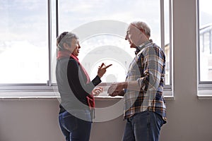 Window, mature couple and communication with smile, conversation and discussion of retirement holiday. House, elderly