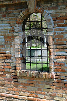 Window with metal grating and brick wall