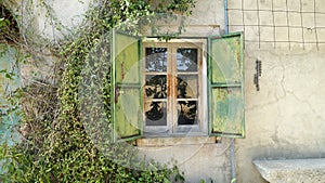 The window with metal shutters of an ancient house in the countryside.