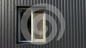 Window of modern house with black metal facade with vertical lines