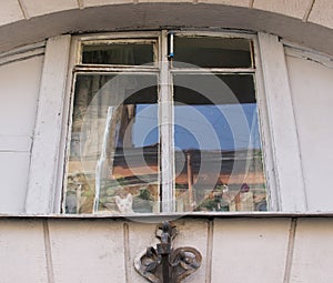 A window in an old house with heterochromatic kitten on a window