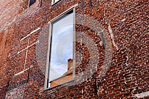 Window on the old red brick building. Old retro house made of the red bricks.
