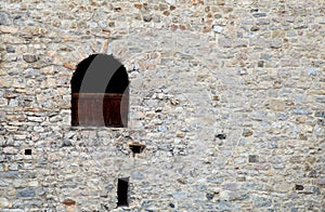 Window in old stone wall of medieval castle