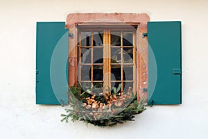 Window with open blue wooden shutters and decoration