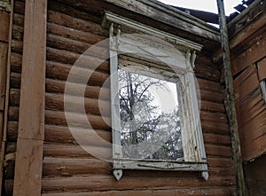 Window opening of an old ruined wooden house. Russia