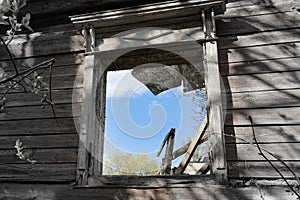 Window opening of an old ruined wooden house. Russia
