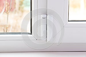 window opening sensor hanging on the window, home alarm system, home protection photo