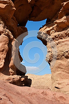 Window in the orange sandstone rock in the desert