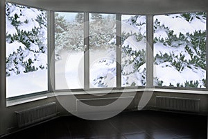 Window overlooking winter forest. Panorama to snowy trees from room windows