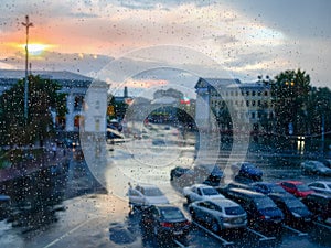 Window pane during a rain, blurred cityscape through the glass