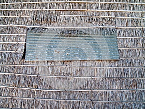 Window panel on thatch wall