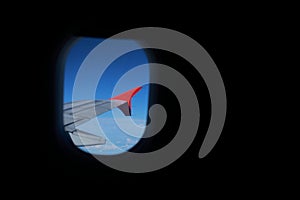 Window plane with wing and blue sky