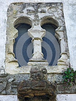 Window of pre-Romanesque origin in the chapel of San Bartolome de Nava cemetery and and the figure of a bear with a wild boar in photo