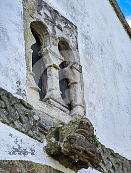 Window of pre-Romanesque origin in the chapel of San Bartolome de Nava cemetery and and the figure of a bear with a wild boar in photo