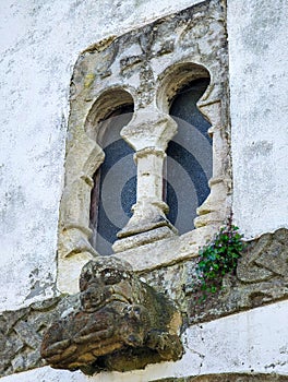 Window of pre-Romanesque origin in the chapel of San Bartolome de Nava cemetery and and the figure of a bear with a wild boar in photo