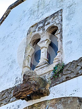 Window of pre-Romanesque origin in the chapel of San Bartolome de Nava cemetery and and the figure of a bear with a wild boar in photo