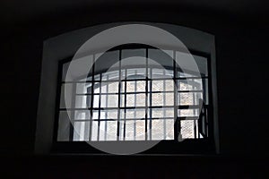 A window in a prison cell, covered with bars