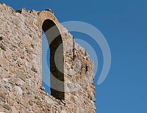 Window remains of ruined building against blue sky