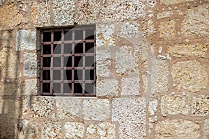 Window with rusty iron bars at a wall