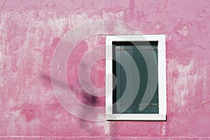 Window shutters closed on pink wall, Burano