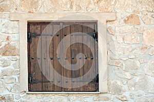 Window shutters on old stone wall. Building facade wall with wooden shutters closed. Architecture structure and design