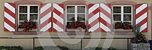 Window shutters in red and white. Panorama