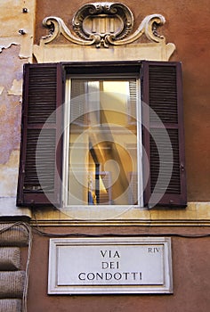 Window with shutters on the street Via del Condotti, Rome, Italy photo