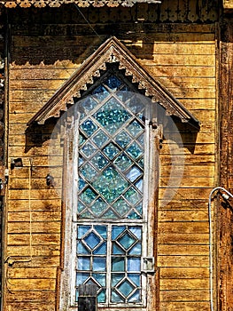 A window with stained glass in an old wooden house.